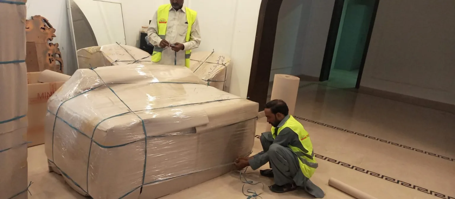 US Packers and Movers crew securing wrapped household goods before loading in Islamabad
